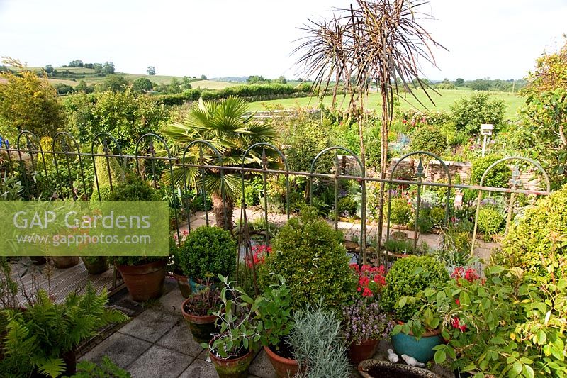Balcony with pots and views of garden and surrounding landscape. Eastfield, Yarlington, Somerset, UK
