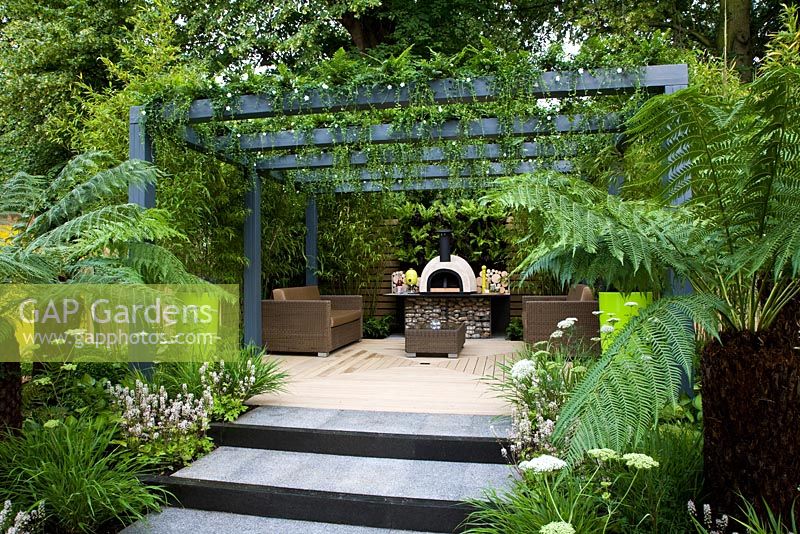 Lush planting to a raised deck and a living pergola. Tree ferms predominate - 'Live Outdoors' - Silver gilt medal winner - RHS Hampton Court Flower Show 2012 
