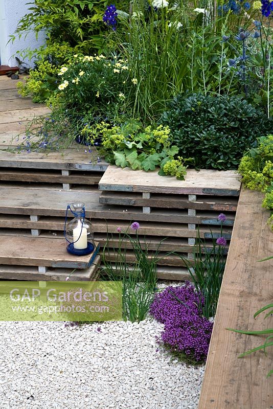 A garden for a young couple with a budget of £7000. Reclaimed scaffold boards and split logs predominate - 'Our First Home, Our First Garden' - Gold medal winner - RHS Hampton Court Flower Show 2012