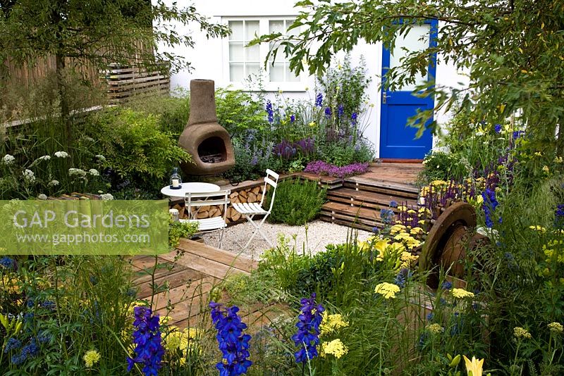A garden for a young couple with a budget of £7000. Reclaimed scaffold boards and split logs predominate. Mixed shrubs and perennials for summer interest - 'Our First Home, Our First Garden' - Gold medal winner - RHS Hampton Court Flower Show 2012 
 