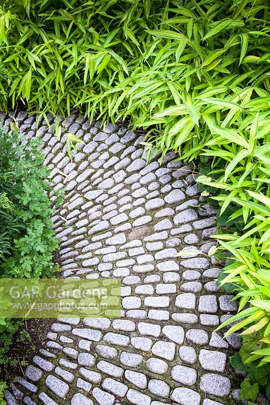 Path made with granite oval stones, edged with bamboo