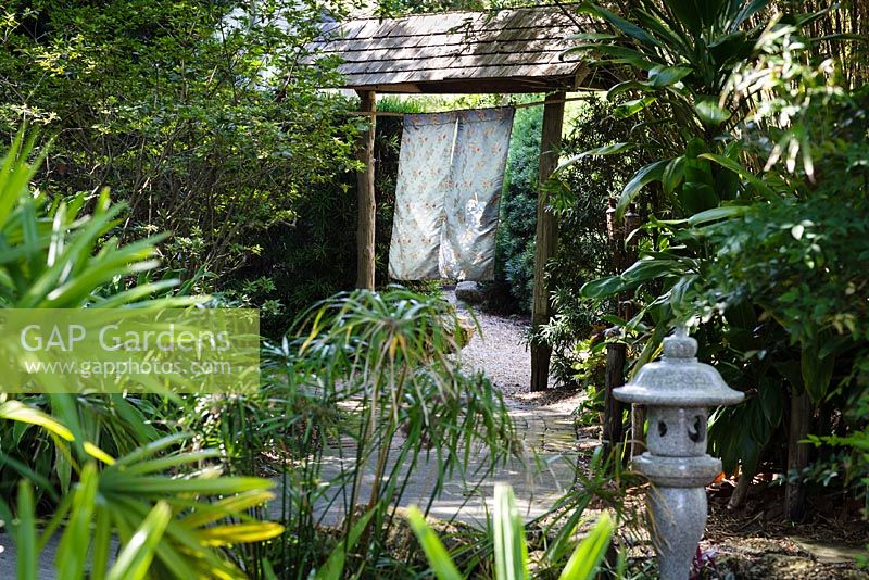 A stone lantern and swaying silk panels leading into the Japanese Garden - Heathcote Botanical Gardens, Florida