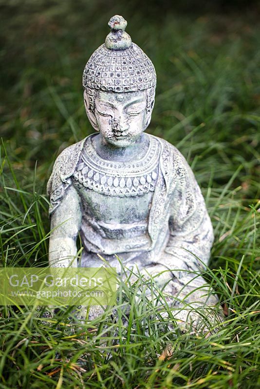 Statue sitting in mondo grass in the Japanese Garden - Heathcote Botanical Gardens, Florida