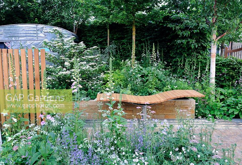 Undulating timber bench in raised bed, with extensive perennial planting - A Celebration of Caravanning Garden, Chelsea 2012