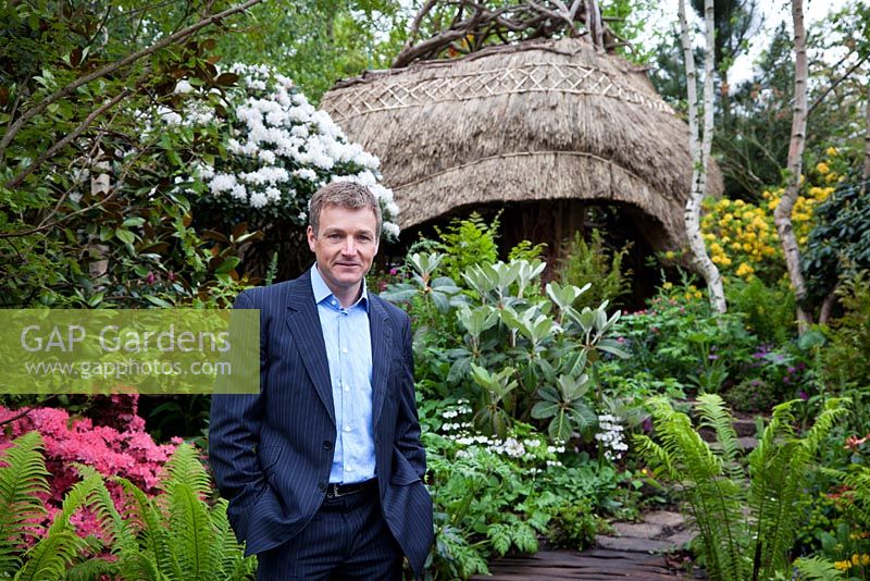 Chris Beardshaw in his gold medal-winning Furzey Garden, standing on the wooden boardwalk leading to the thatched Lantern building