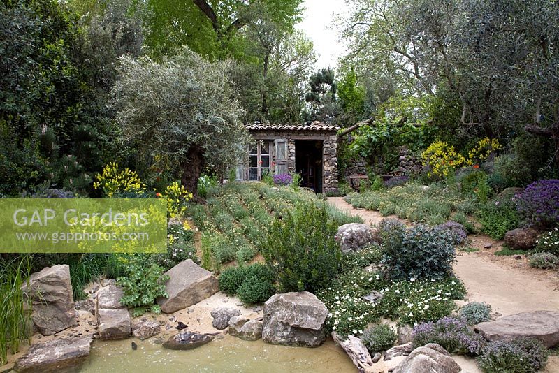 L'Occitane Garden - Evoking Corsican gardens and flowers, with a sandy beach footpath and a stone cabin.