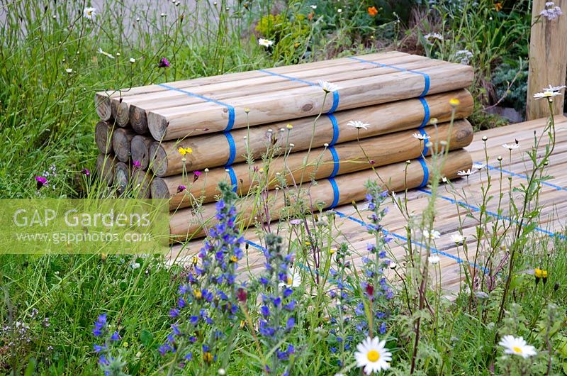 Bench made of fence posts bound with blue straps, surrounded by Wildflowers - Out of the Blue, RHS Chelsea Flower Show 2012