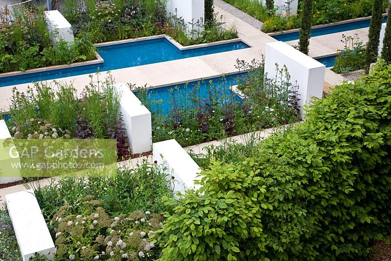 Linear rills and canals reminiscent of the Alhambra in Spain. A trulli building with conical drystone roof - RHS Chelsea Flower Show 2012