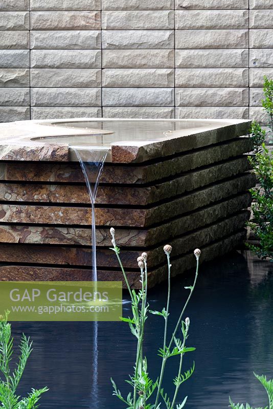 Yorkshire stone water feature with contemporary stone wall behind - Homebase Teenage Cancer Trust Garden, Gold Medal winner - RHS Chelsea Flower Show 2012 