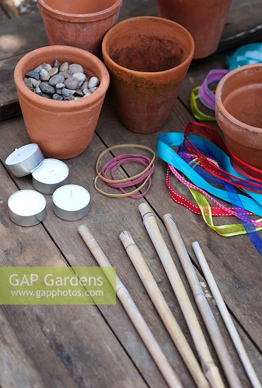 Materials needed for making garden tealight holders - Plant pots, bamboo canes, elastic bands, ribbons and shingle