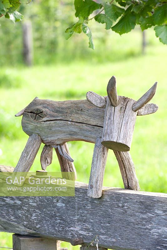 Carved wooden cow ornament on fence 
