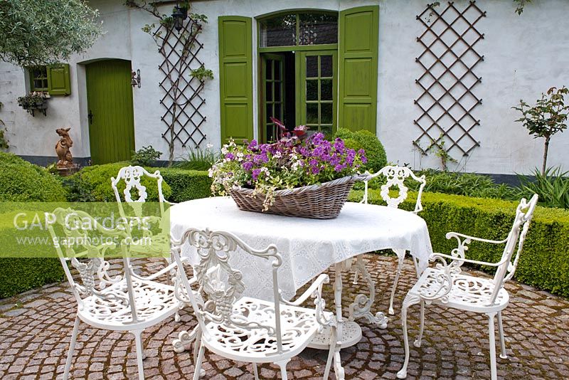 Relaxing area on a paved terrace surrounded with hedging,  De Romantische tuin - The Romantic Garden of Dina Deferme and Tony Pirotte