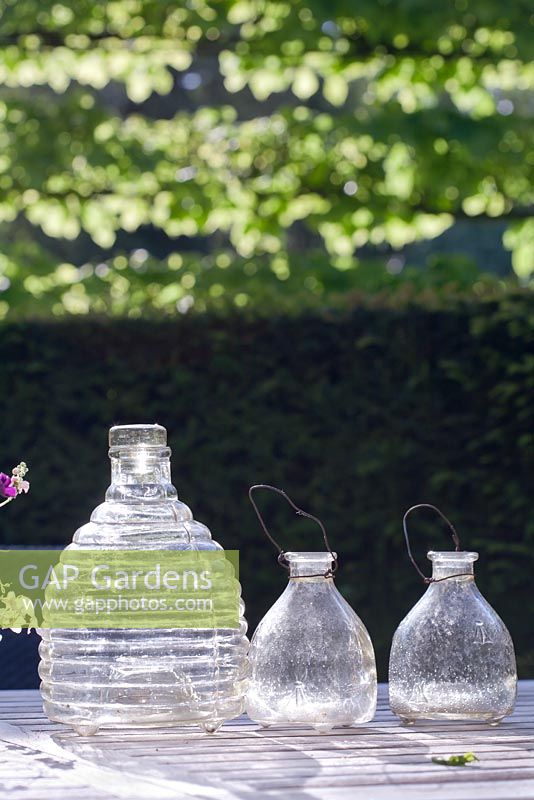 Decorative glass bottle on the table, De Romantische tuin - The Romantic Garden of Dina Deferme and Tony Pirotte