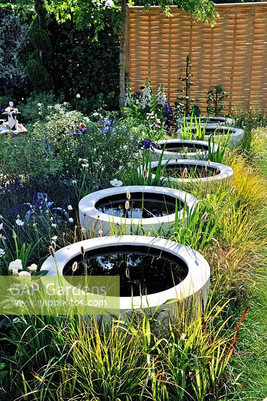 Row of Glass fibre resin containers as mini ponds. Celebration and Jubilation garden. Hampton Court palace Flower show 2012