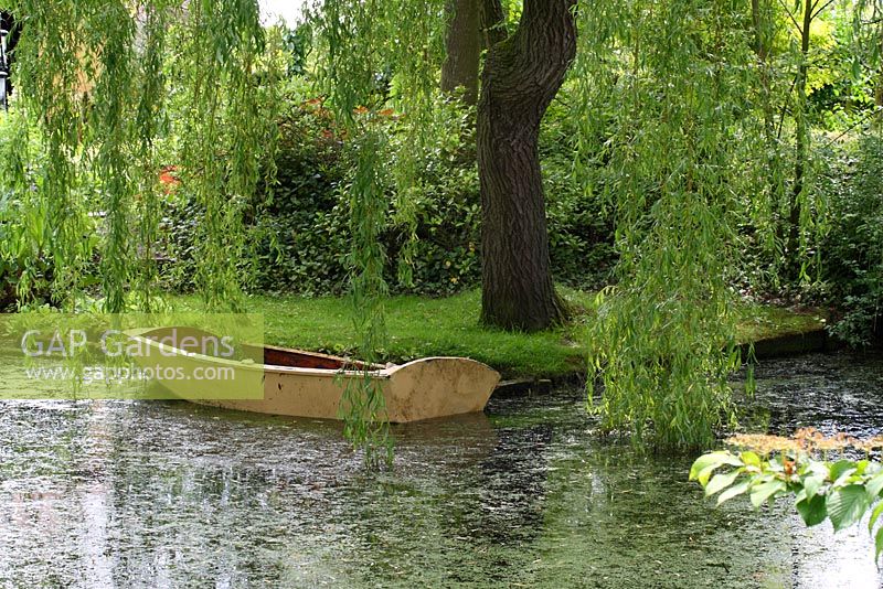 Old wooden rowing boat in the pond shaded by a weeping willow tree - Sallowfield Cottage B&B, Norfolk