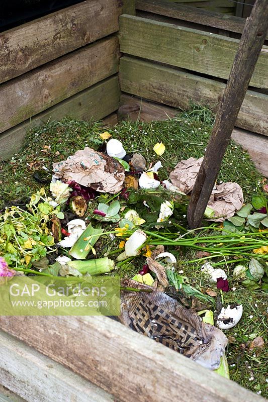 Wooden compost bin showing household waste and grass clippings