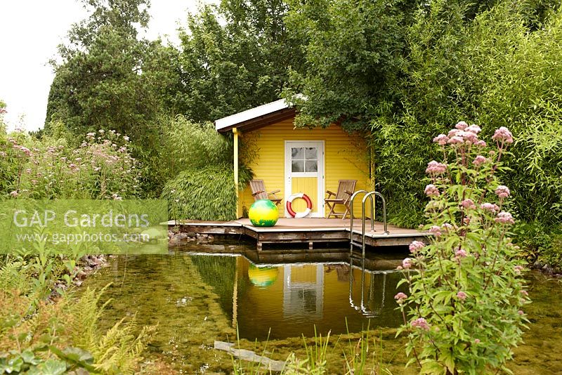 Garden shed next to pond with wooden landing