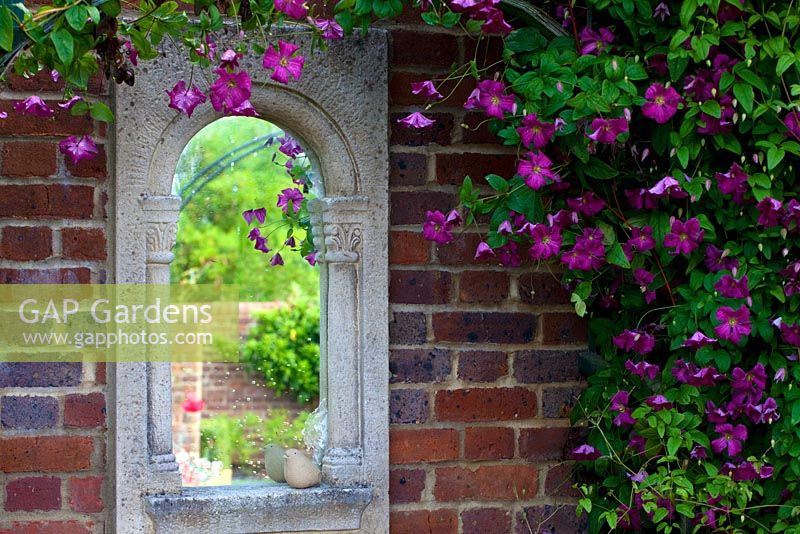 Mullion style mirror on brick wall with clematis 