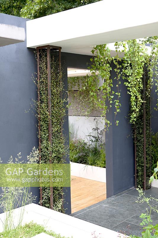 Urban garden- Falling leaves - with vertical planting in structural pillars and planting under the seats. Hampton Court Palace Flower show 2012