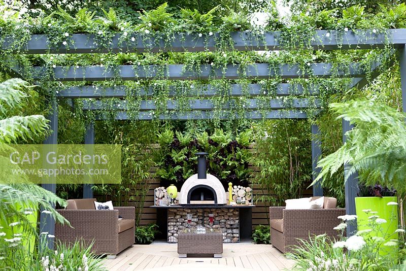Seating and cooking area with living pergola planted with ferns, Tellima Grandiflora and Dicksonia along garden steps - Live Outdoors, Hampton Court palace flower show 2012.