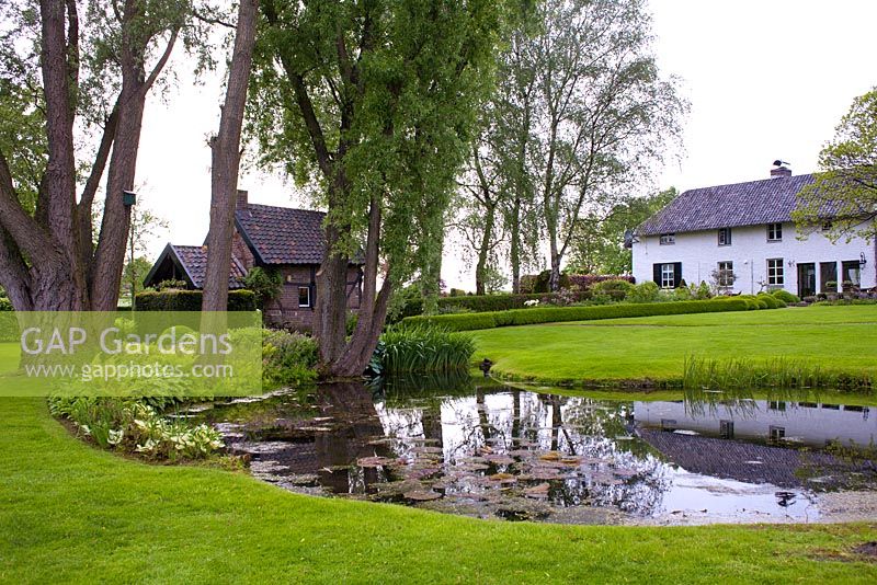 View of the garden with pond in foreground backed by house, De Carishof