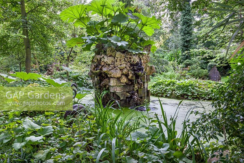 Water feature, in the Stumpery with Gunnera, Giant South American Rhubard, Highgrove Garden, August 2012. The water feature is made of Hereford red sandstone and Spanish limestone.   