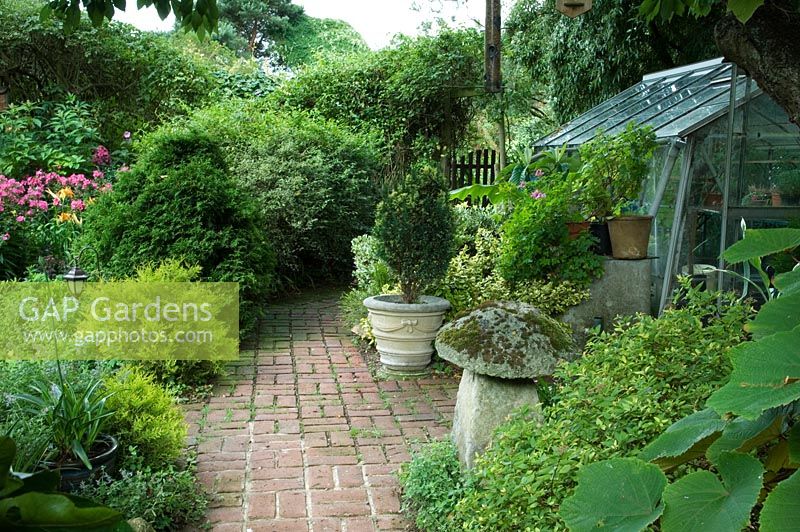 Wildlife conservation garden with brick path and greenhouse
