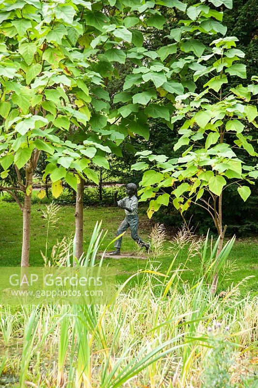 Sculpture of child in wild garden. Ragley Hall, Alcester, Warwickshire, UK