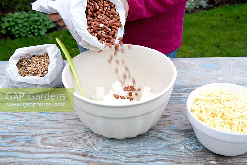 Step by step for creating hanging bird feeders out of teacups and yoghurt pots - adding peanuts 