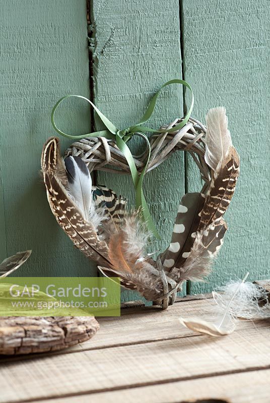 Twig heart decorated with birds feathers