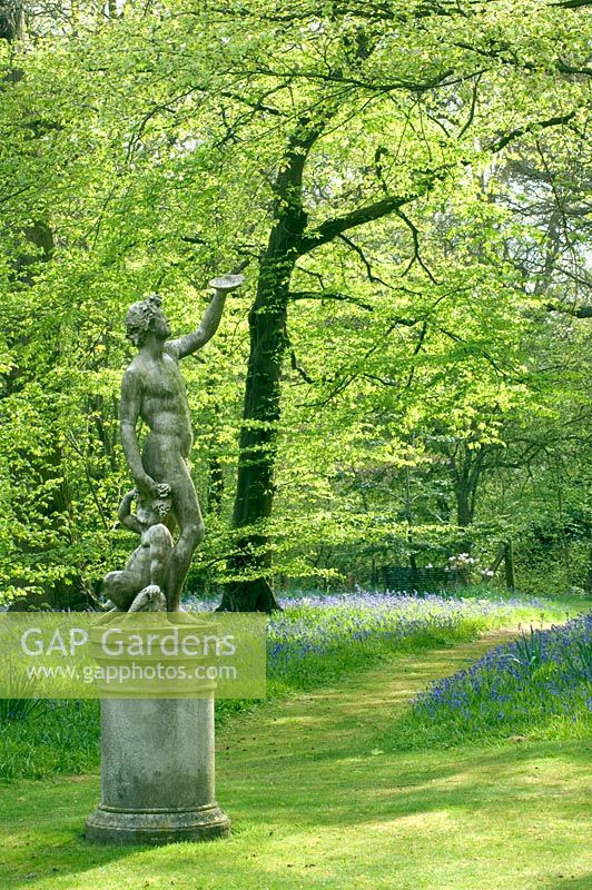 Stone sculpture in woodland garden, spring 