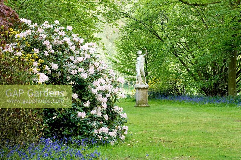 Stone statue in woodland garden, spring 