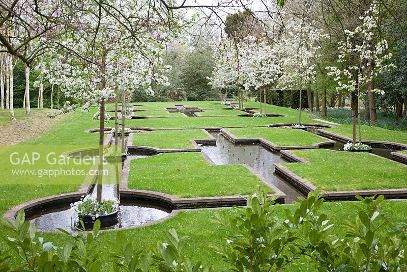 The Paradise Garden with Malus 'Evereste' blossoming in spring - West Green House, Hampshire