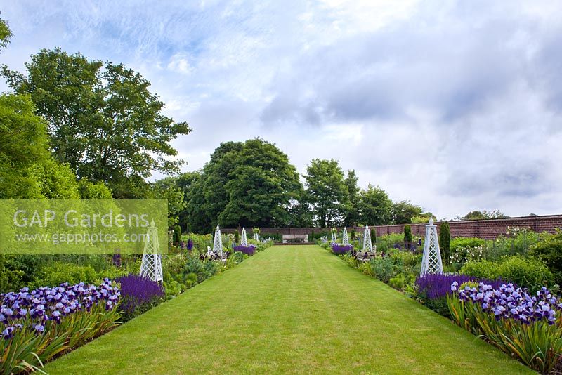 Formal garden with wide grass path and obelisks. Double Mirrored Borders at Old Bladbean Stud.
