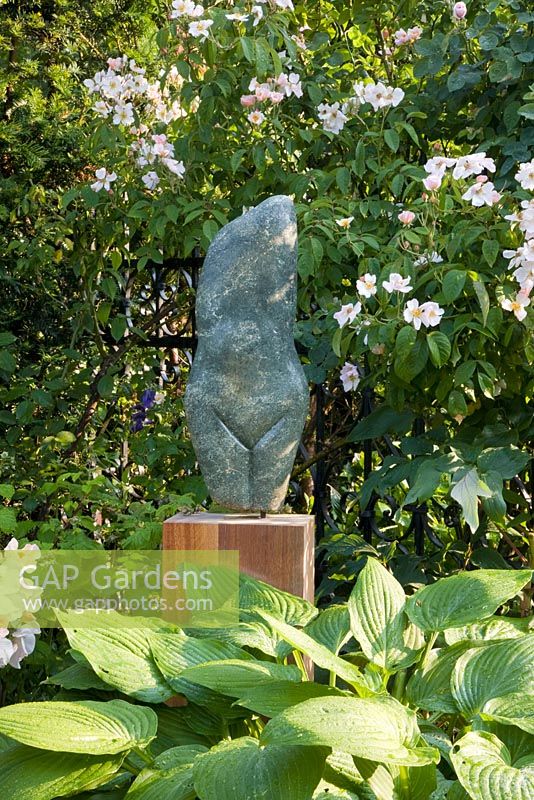 Statue in garden on wooden plinth