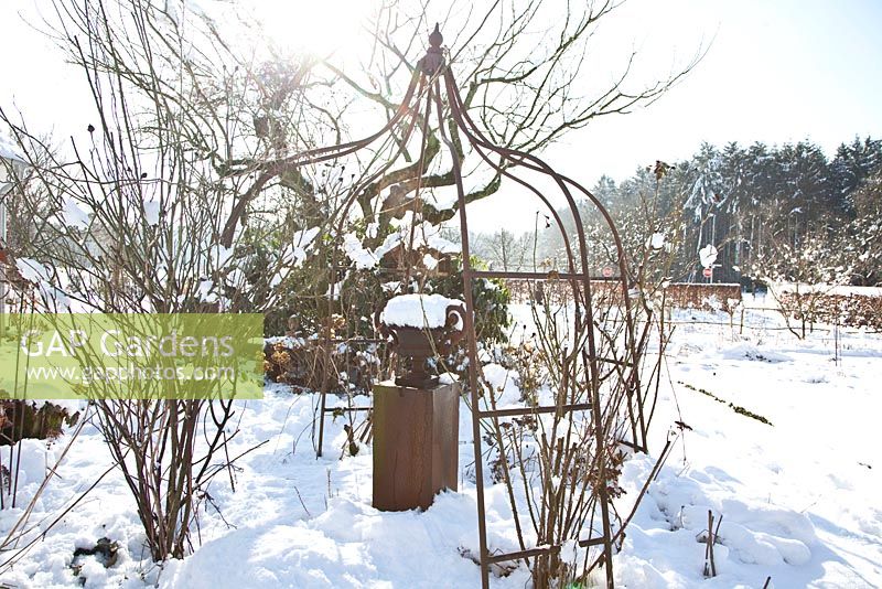 Garden in winter with metal gazebo