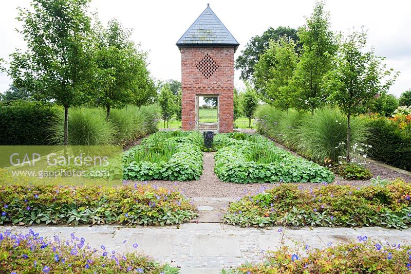 Dovecote built in 2007 to reflect the barn, with planting including Pyrus calleryana 'Chanticleer', Miscanthus sinensis 'Morning Light', Verbena bonariensis and Alchemilla mollis - Rhodds Farm, Kington, Herefordshire, UK