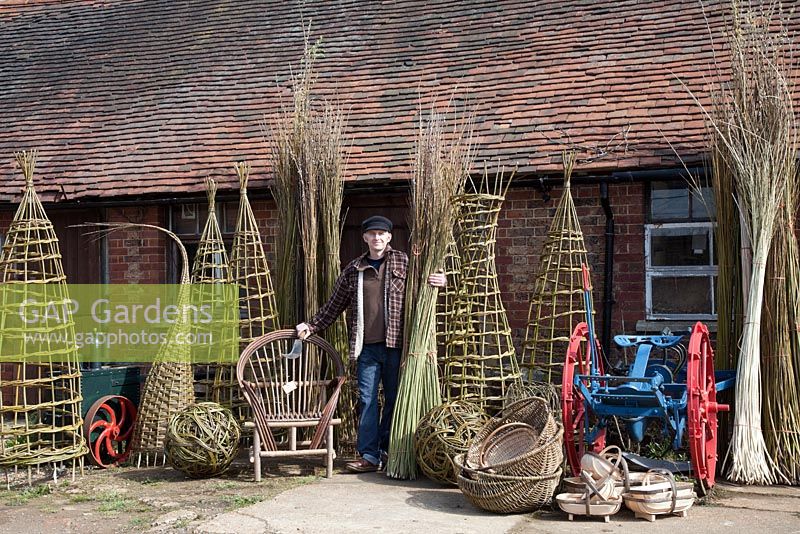 Willow weaver Dominic Parrette with a variety of his creations, plants supports, sculptural sphere, Gypsy chair, trugs and baskets - Sussex Willow 

