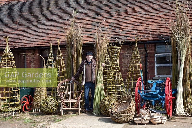 Willow weaver Dominic Parrette with a variety of his creations, plants supports, sculptural sphere, Gypsy chair, trugs and baskets - Sussex Willow 