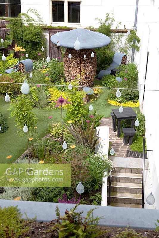 Modern courtyard garden - chicken wire has been used to suspend multiple bird feeders 