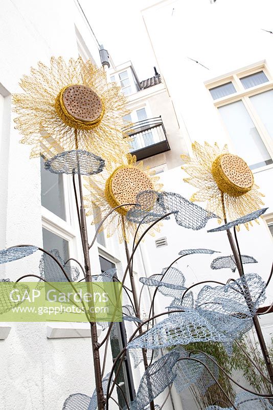 Decorative insect habitats made from wire and wood to look like large sunflowers 
