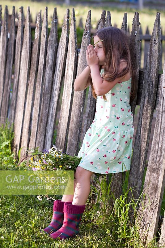 Girl whistling with a blade of grass.