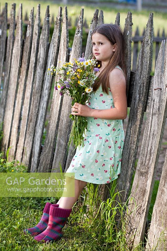 Girl holding bouquet of meadow flowers. Daisy, meadow sage, Scabious, buttercup, comfrey and ragged Robin