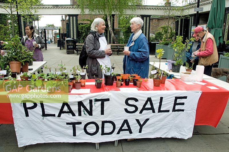 Banner saying plant sale today with two women talking behind the stall, Highbury Barn, London Borough of Islington, UK