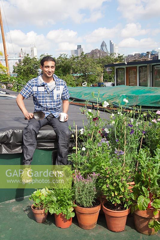 The Thames Garden Barges. Tenant Ruben's barge and his potted garden with Sweet Peas, Chard, Lavandula, Sedum, Nasturtians and herbs and city views of Tower Bridge and The Gherkin.