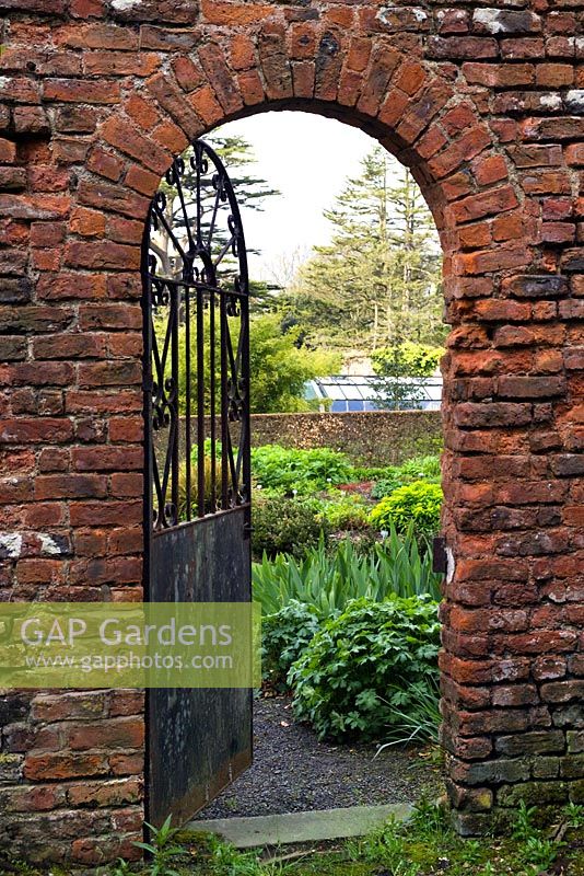 Old metal gateway leading to the perennial beds and orchard of Cally Gardens Nursery