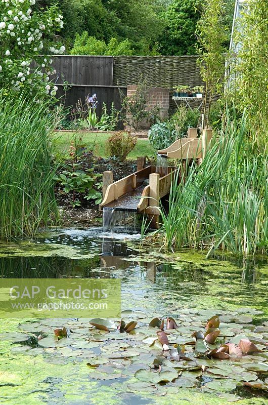Modern water feature supplying garden pond through constructed wooden rills - Open Gardens Day 2013, Bardwell, Suffolk