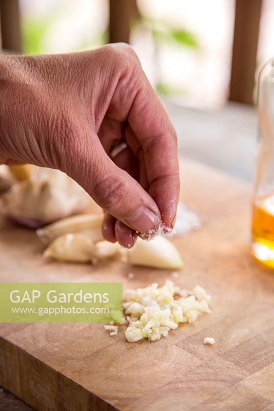 Step by step - Adding salt to chopped garlic 'Early Purple Wight'