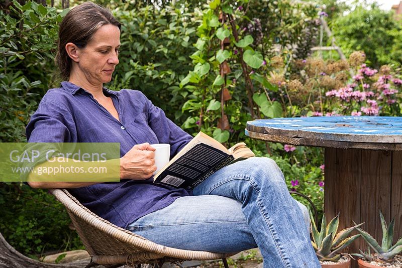 Female gardener reading in the garden