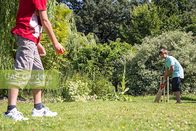 Children playing cricket in the garden